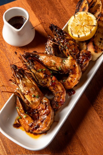 Barbecue shrimp glazed and charred on a platter